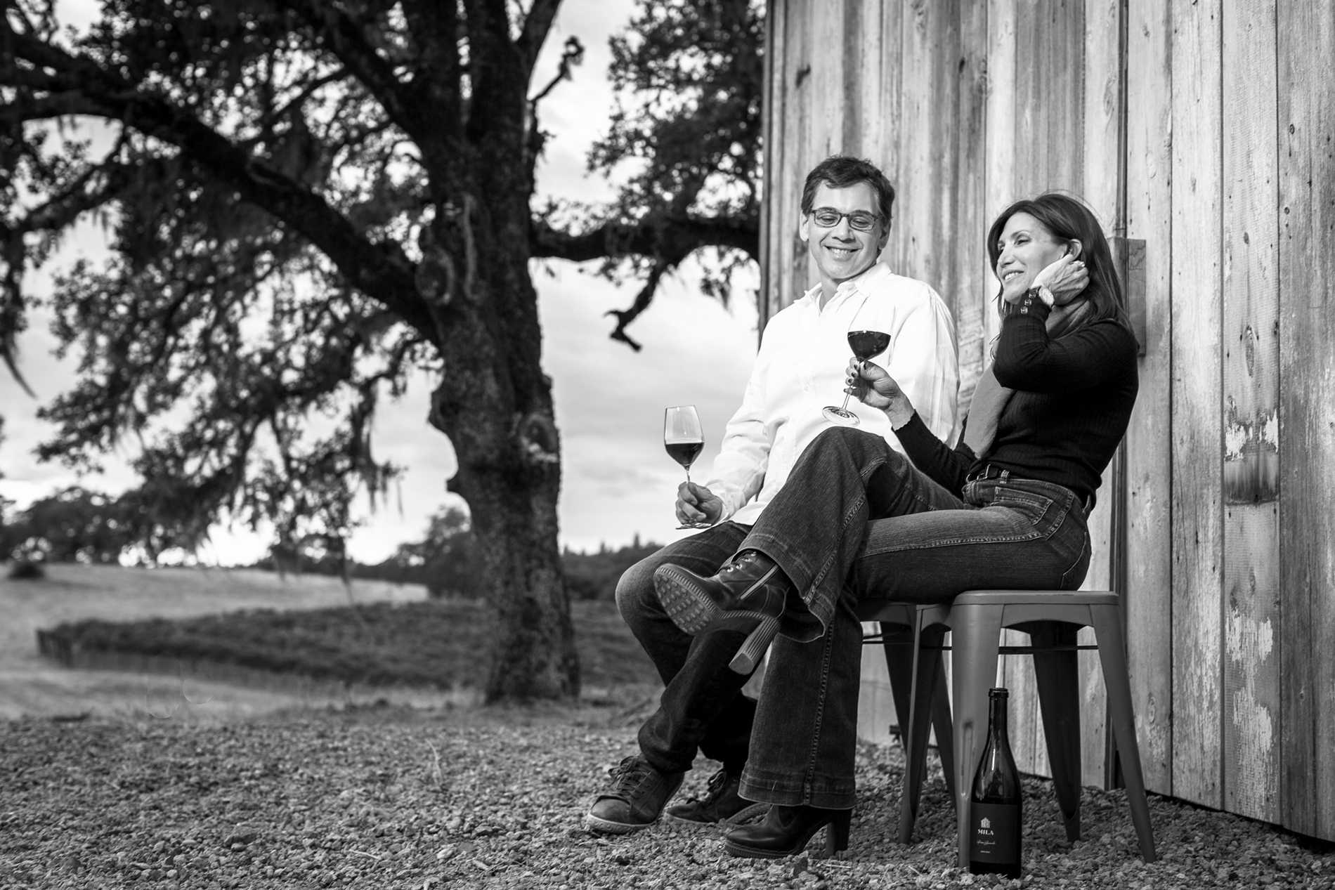 B&W shot of Michael and Loretta sitting next to barn