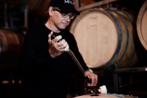 Michael taking wine from barrel